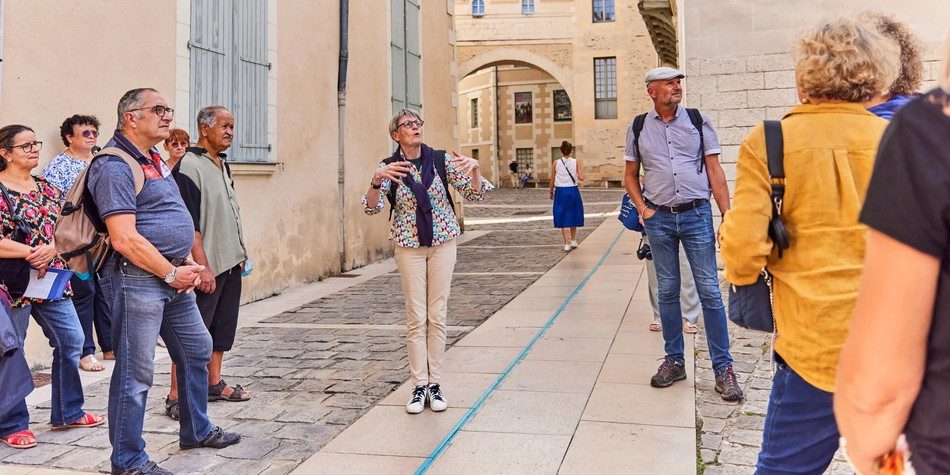 Groupe de touristes écoutant un guide lors d'une visite guidée dans une vieille ville